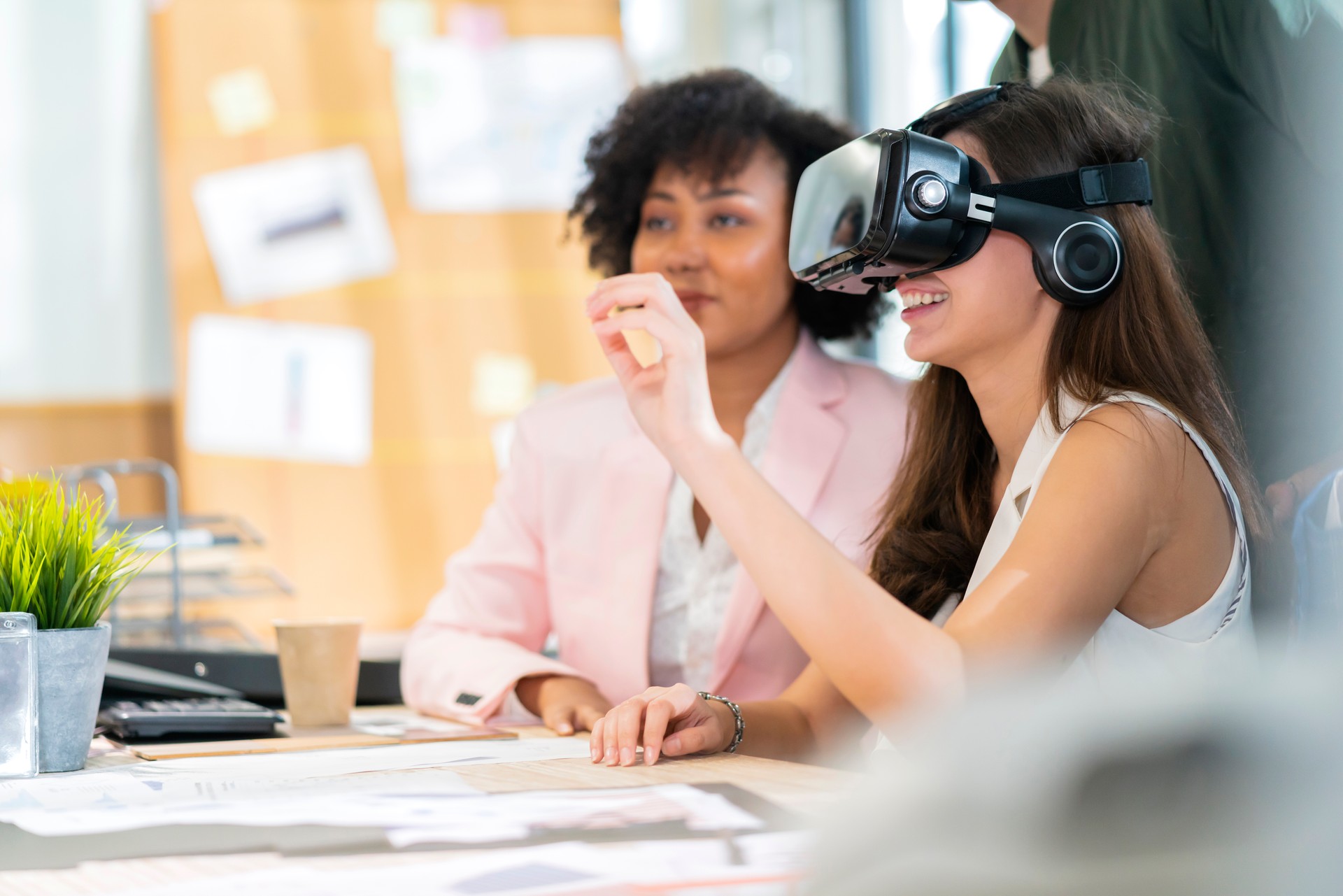 group of millennial male and female multiethnic using vr goggle to test metaverse meeting system cheerful and smiling,office friend standing discussion together next to window office background